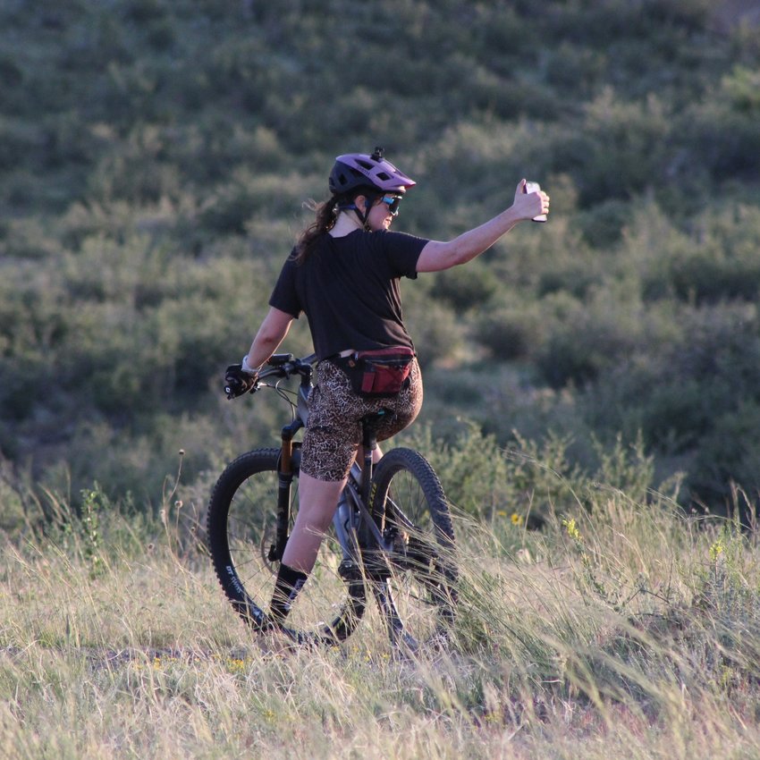 A cyclist takes photos atop South Table Mountain's Dome Flow Trail on June 16.
